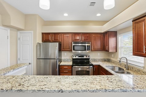 A kitchen with granite countertops and stainless steel appliances.