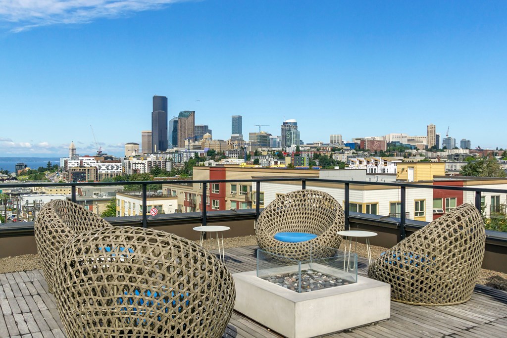 a view of the city skyline from a balcony with chairs and tables