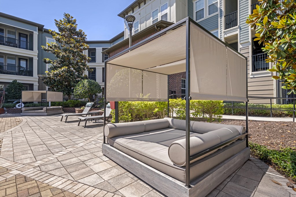 a patio with a couch and chairs under an awning