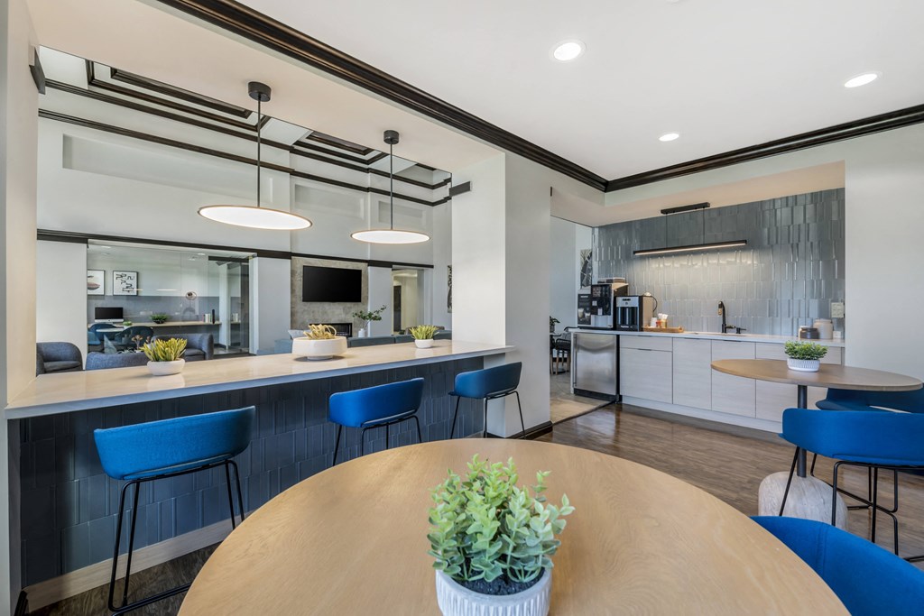 a dining area with a table and chairs and a kitchen in the background