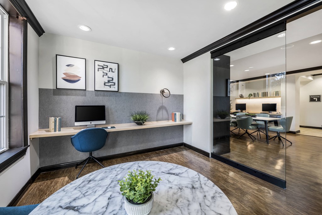 a room with a table and chairs with a computer monitor on top of it