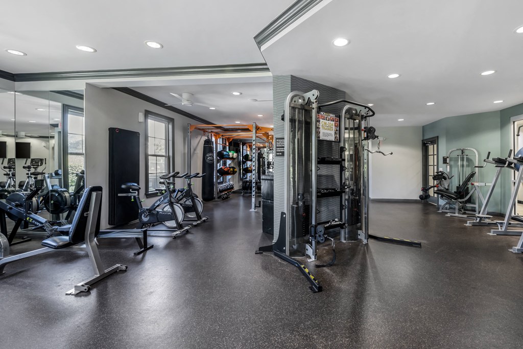 a spacious fitness room with cardio machines and weights
