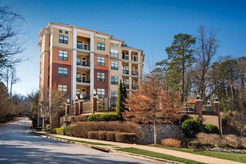 A tall apartment building with a balcony on the second floor.