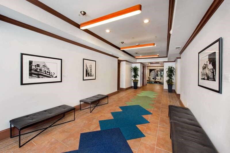 a long hallway with benches and paintings on the wall