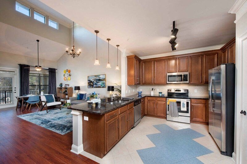A kitchen with wooden cabinets and a black countertop.