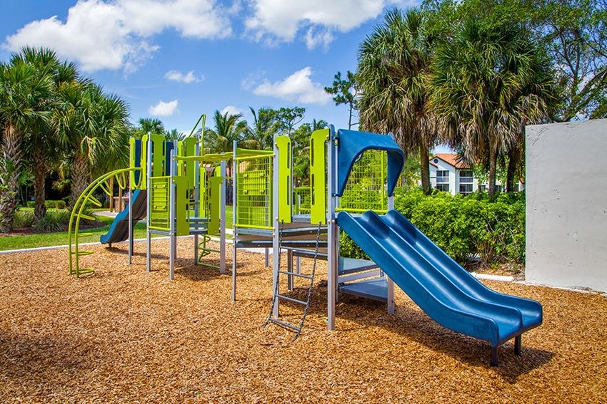 a playground with a blue slide and yellow equipment