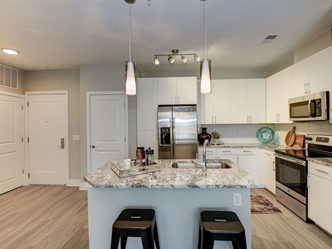 a kitchen with a counter top with three stools