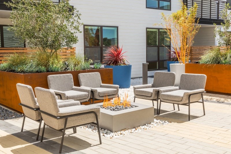 an outdoor patio with chairs and a fire pit
