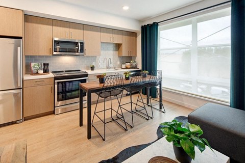 a kitchen with a bar and a table with chairs