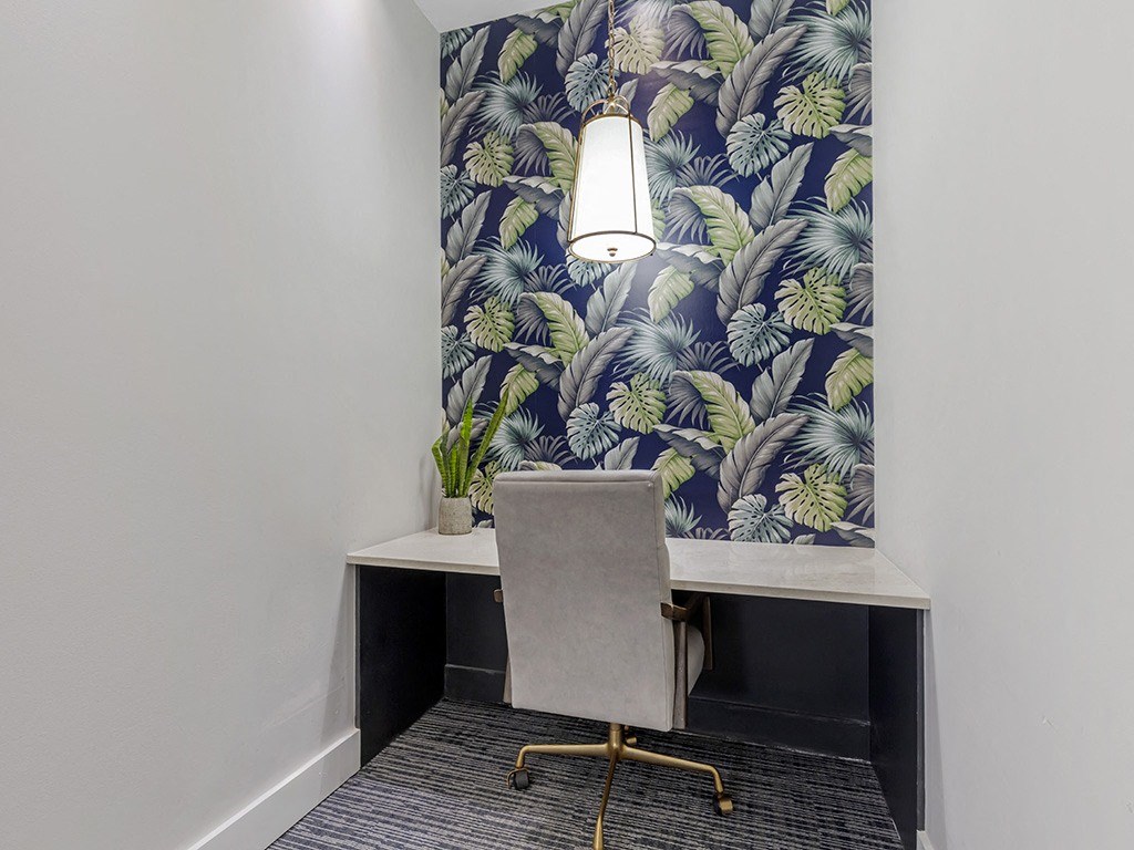 a desk with a chair and a lamp in a room