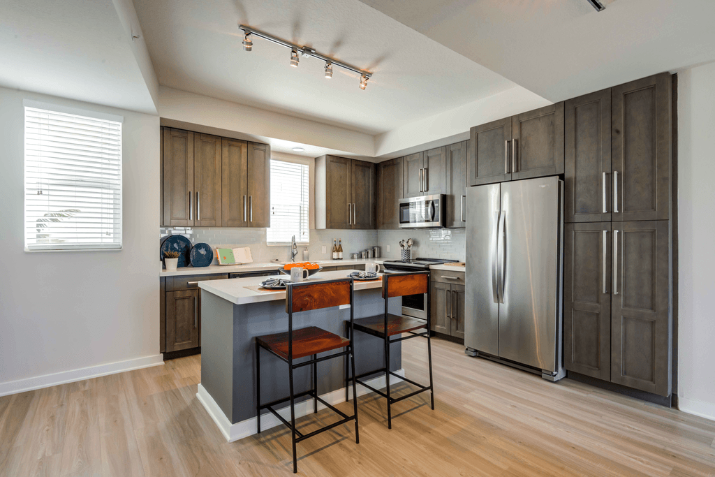 A kitchen with a bar stool in front of a counter.