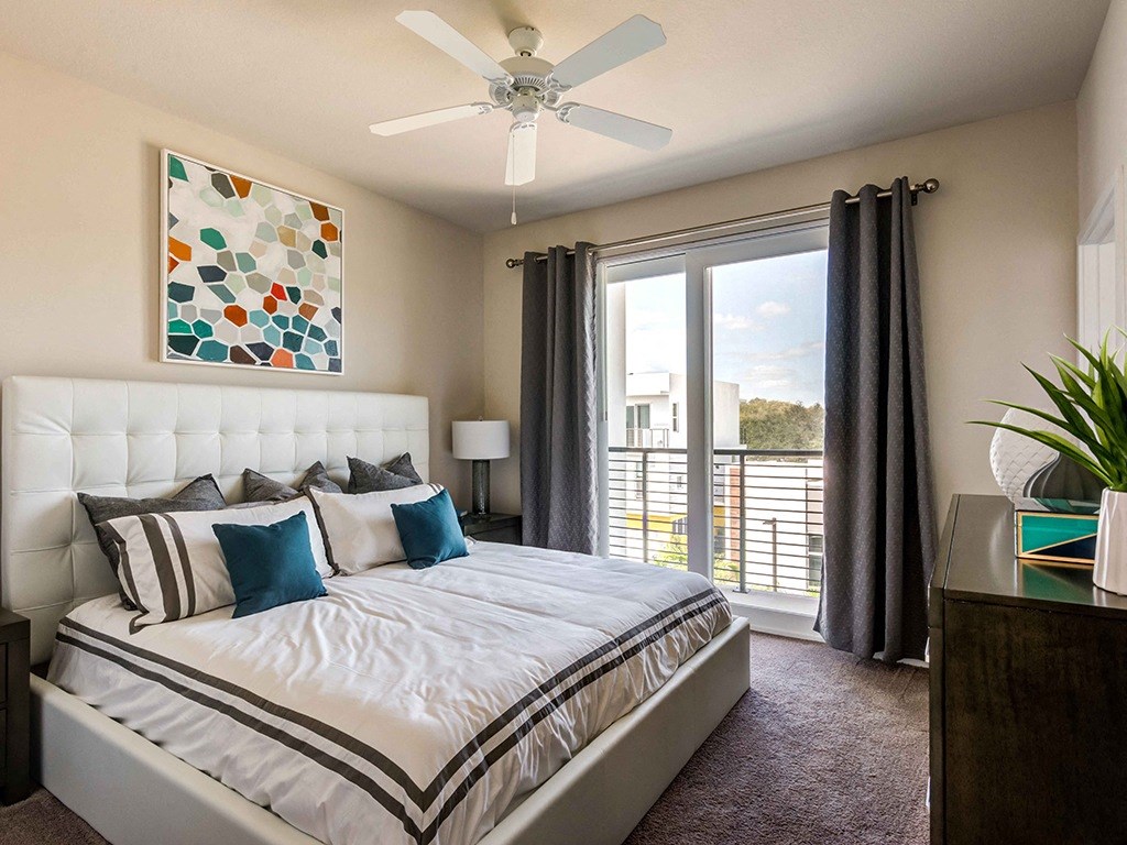 A bedroom with a large bed and a painting on the wall.