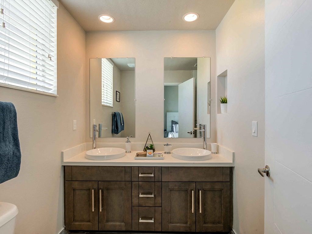 A bathroom with two sinks and a large mirror.