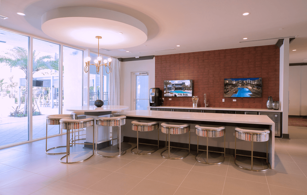 A modern kitchen with a bar area and a television mounted on the wall.