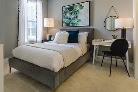 a bedroom with a bed and a desk with a chair