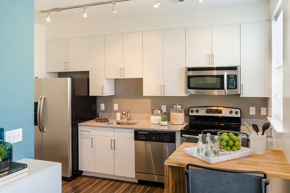 a kitchen with white cabinets and stainless steel appliances