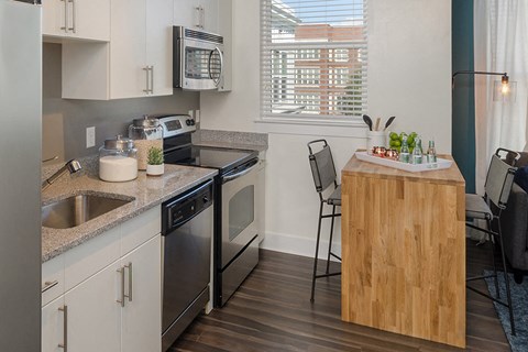 a kitchen with stainless steel appliances and a counter with a wooden island