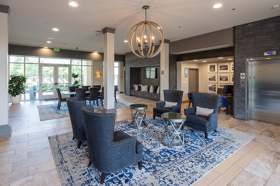 a lobby with couches and chairs and a chandelier