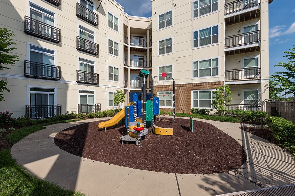 an outdoor playground in front of an apartment building