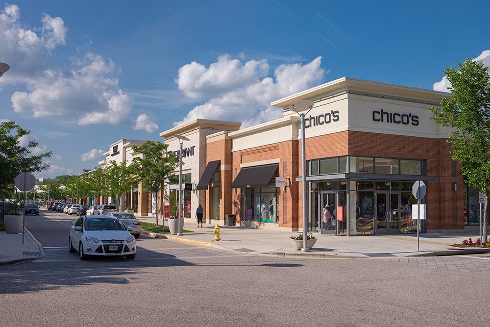 a city street with a car parked in front of a store