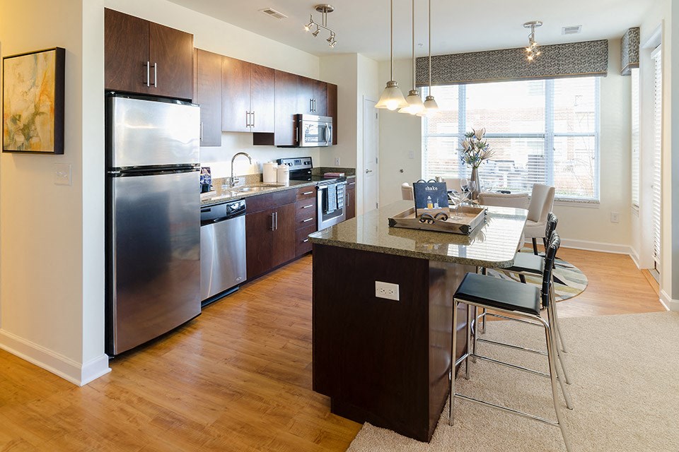 a kitchen with stainless steel appliances and a table with chairs