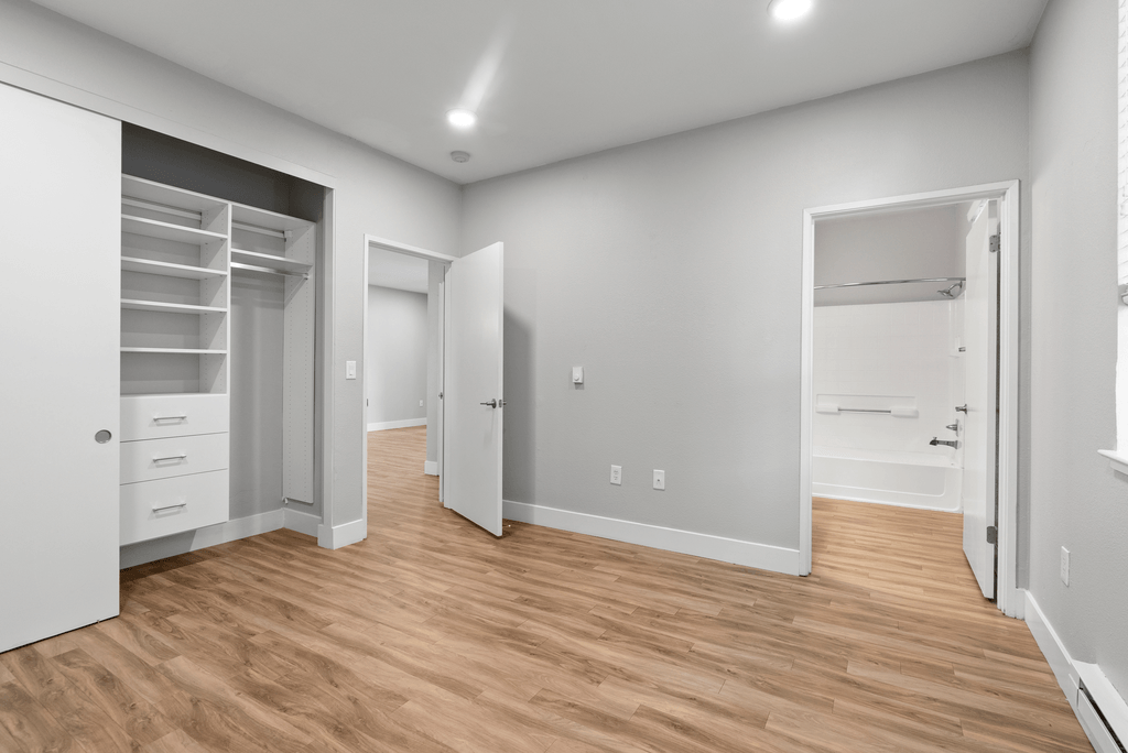 A room with a white wall and a wooden floor.