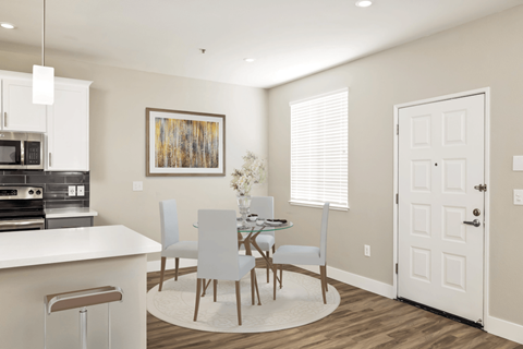 A modern kitchen with a dining table and chairs.