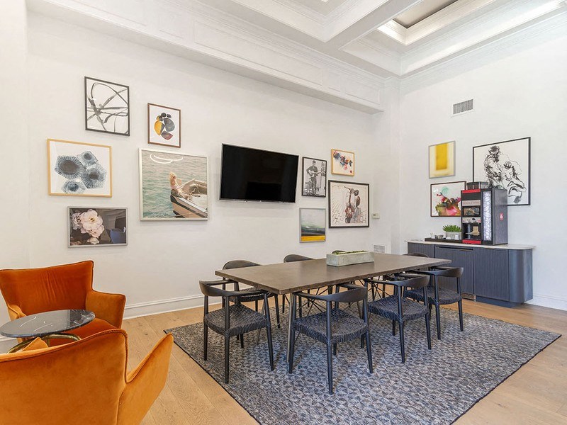 a conference room with a long table and chairs and a flat screen tv on the wall