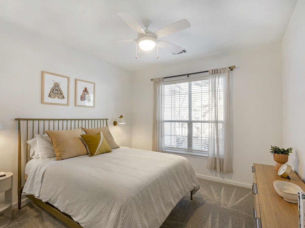a bedroom with a bed and a ceiling fan
