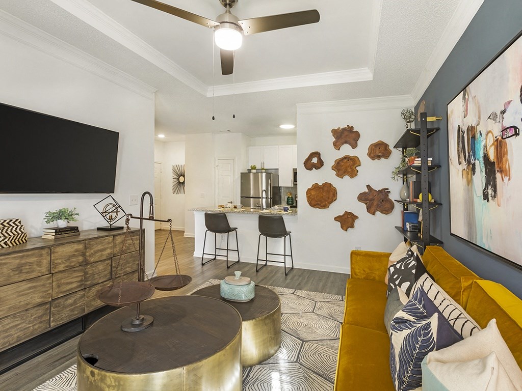 a living room with a yellow couch and a tv on the wall