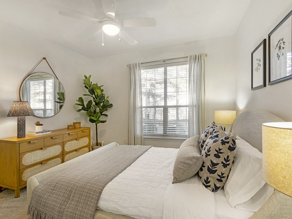 a bedroom with a bed and a dresser with a mirror