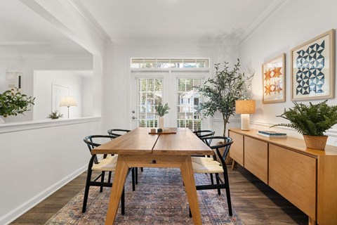 A dining room with a wooden table and chairs.