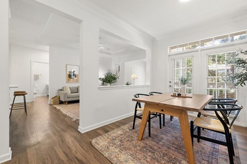 A dining room with a wooden table and chairs.