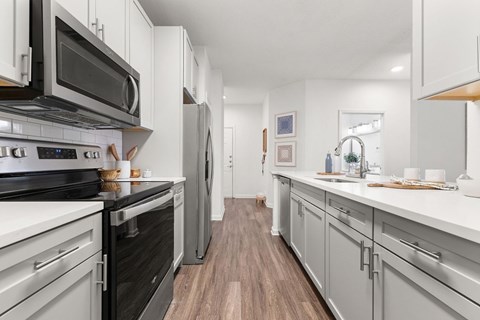 A kitchen with a black stove top oven and a black microwave.