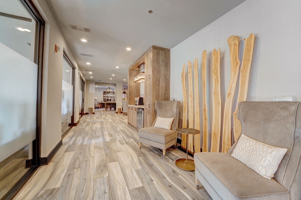 a living room with a couch and chairs and a hallway with wood floors