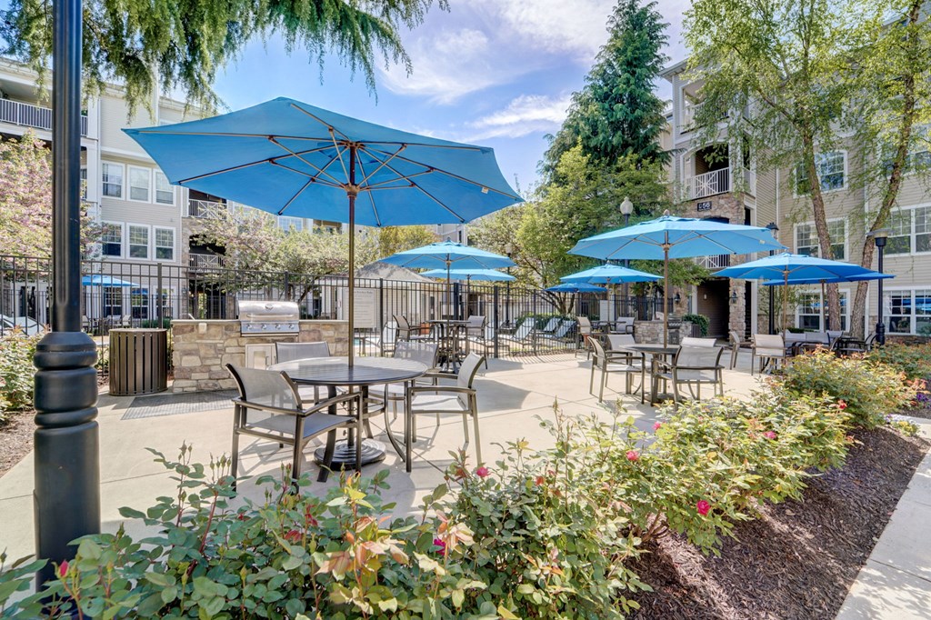 a patio with blue umbrellas and tables and chairs