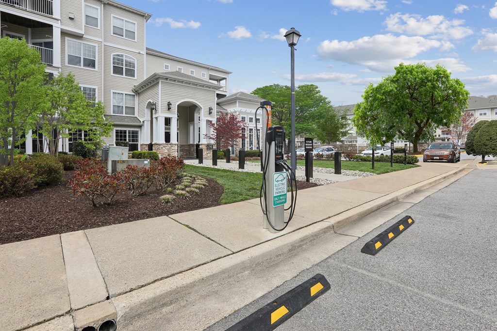 an electric car charger on the sidewalk in front of houses