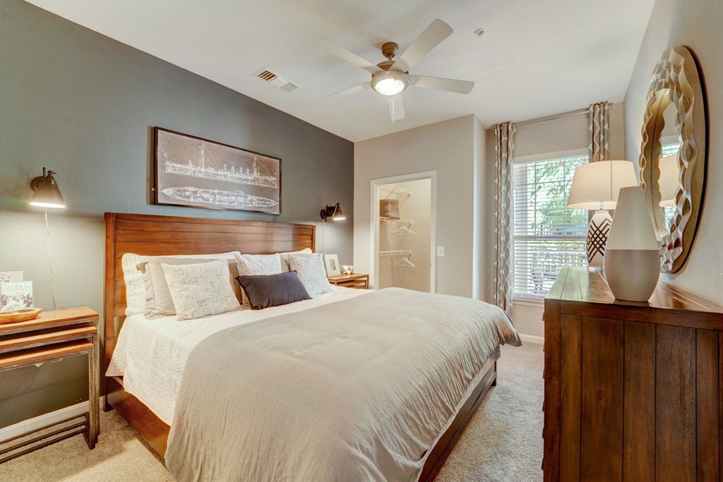 a bedroom with a large bed and a ceiling fan