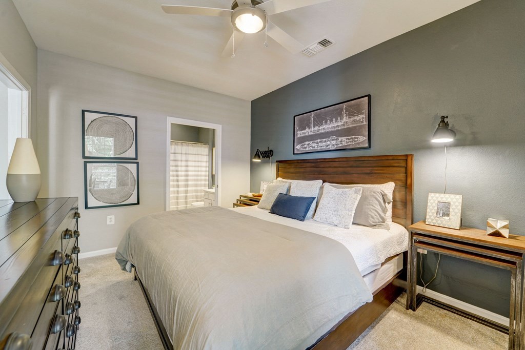 a bedroom with a large bed and a ceiling fan