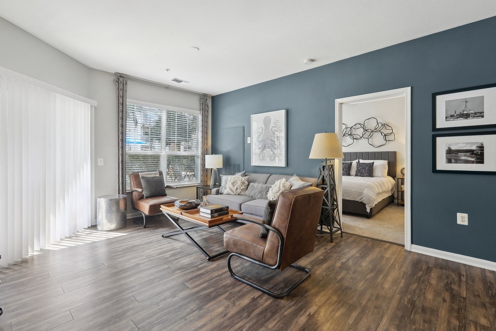 a living room with blue walls and a couch and chairs