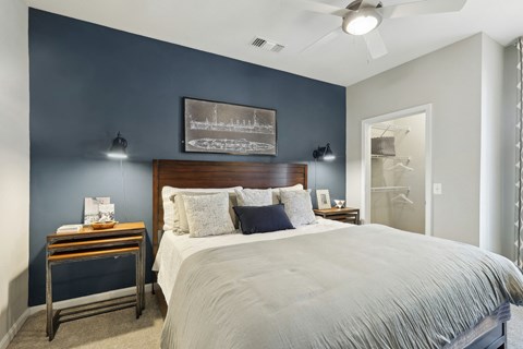a bedroom with a large bed and a blue accent wall