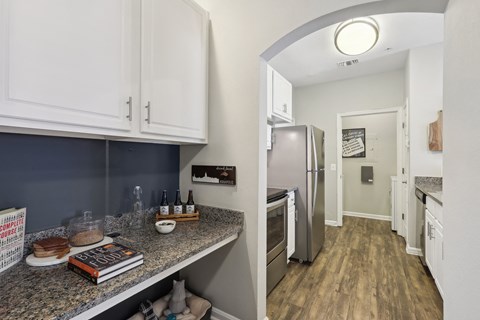 A kitchen with a refrigerator, cabinets, and a counter with a book and a plate of pancakes.
