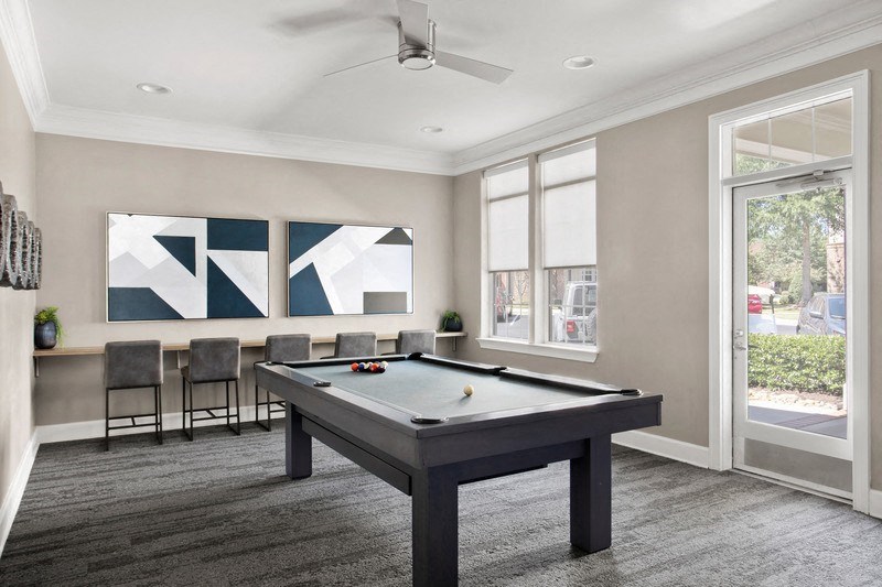 a game room with a pool table and chairs