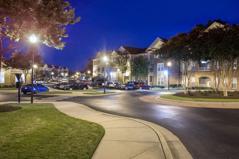 a street corner at night with apartment buildings in the background