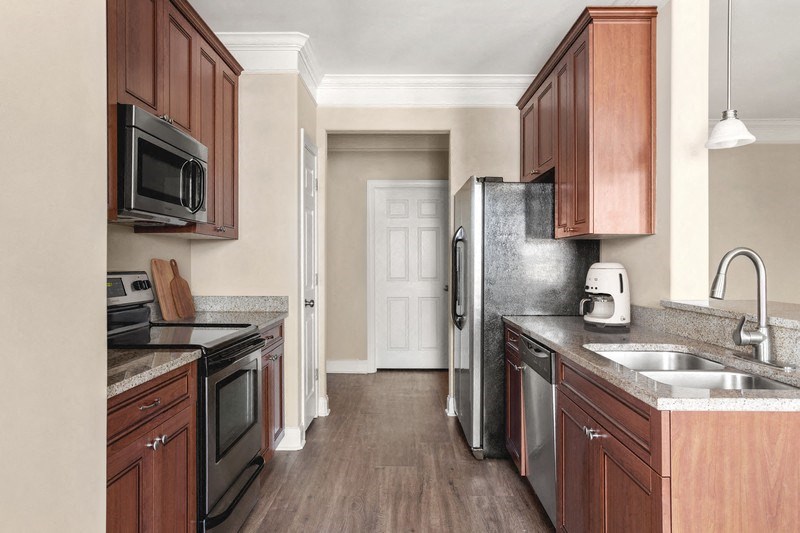 a kitchen with dark wood cabinets and stainless steel appliances