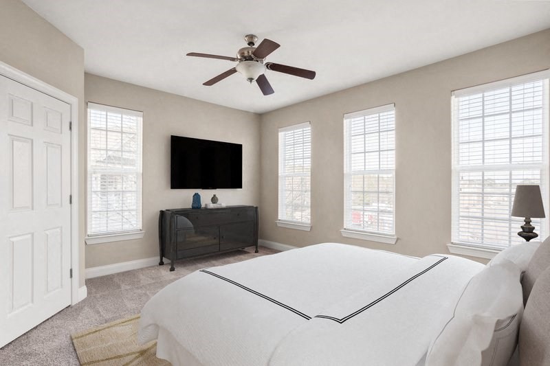a bedroom with a large bed and a ceiling fan