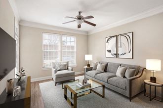 a living room with a ceiling fan and two windows