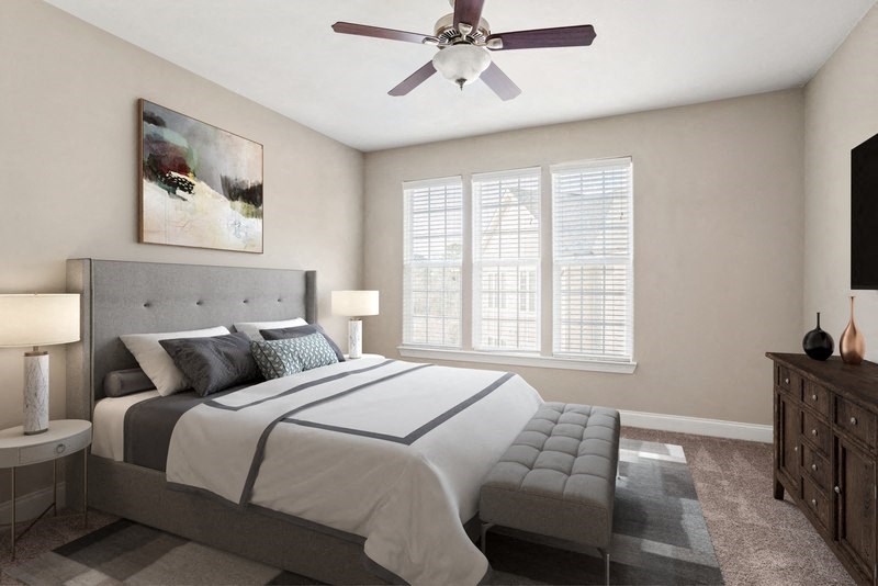 a bedroom with a large bed and a ceiling fan