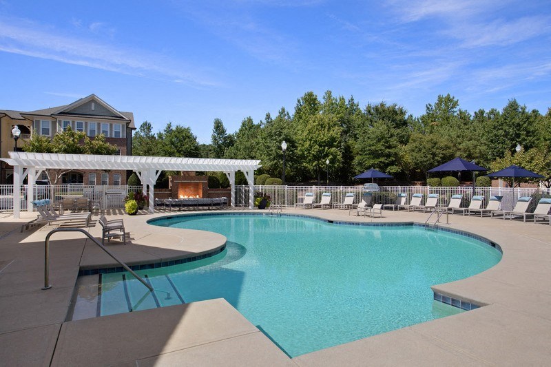 a resort style pool with lounge chairs and a fire pit