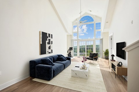 a living room with a blue couch and a large window